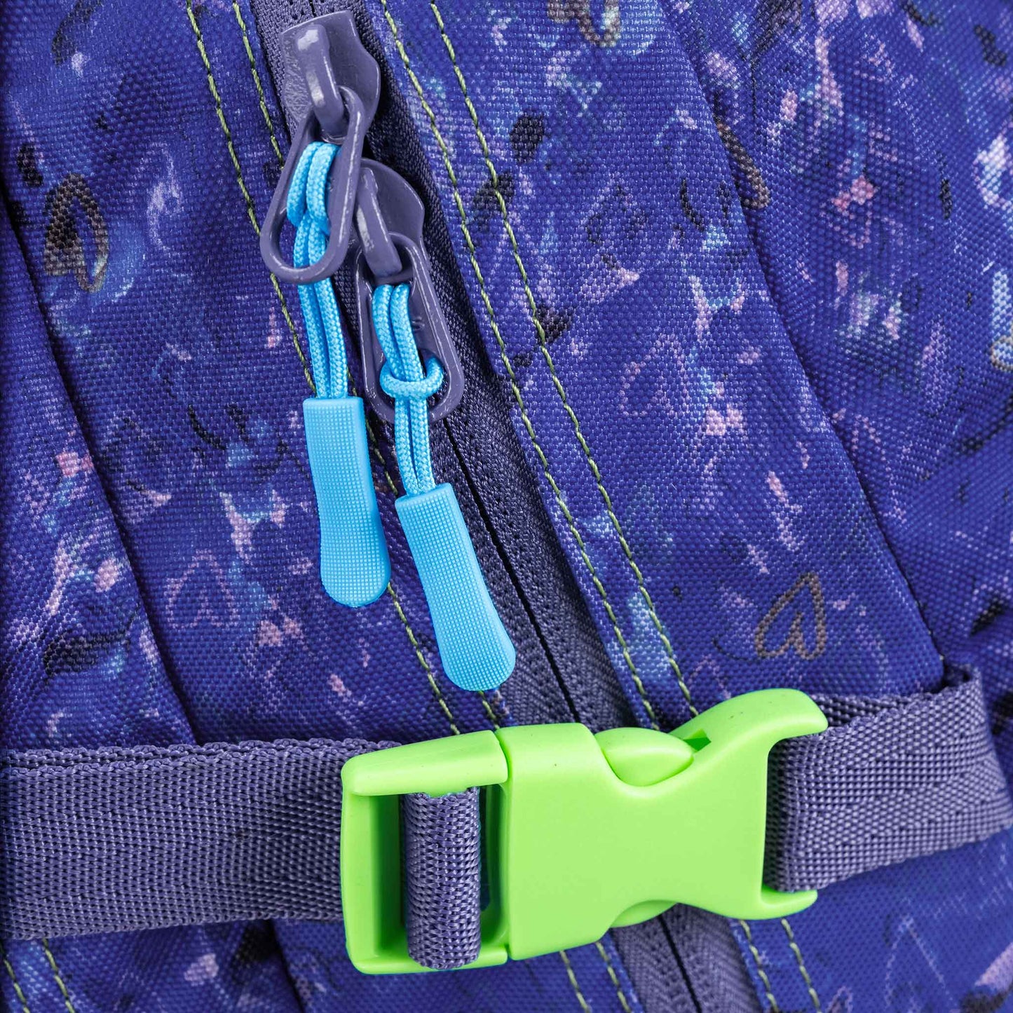 Backpack close-up showing blue zip pullers, lime green buckle clip, grey webbing strap, and blue floral-print fabric with green stitching