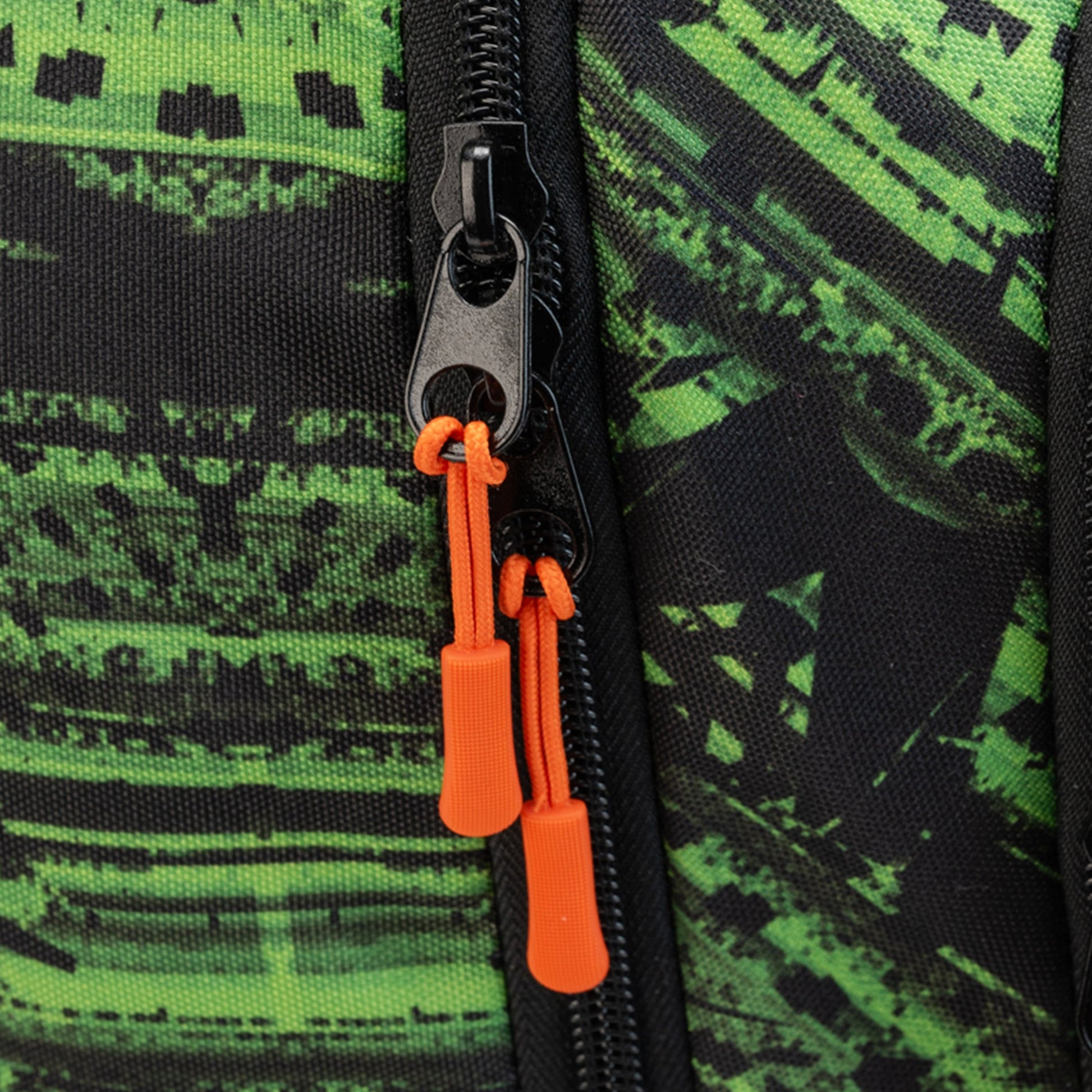 Backpack close-up showing black zip with orange cord pullers on green and black graphic-print polyester fabric